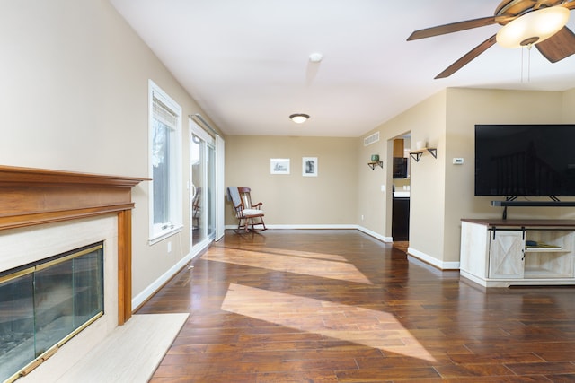 unfurnished living room with visible vents, baseboards, wood finished floors, and a fireplace