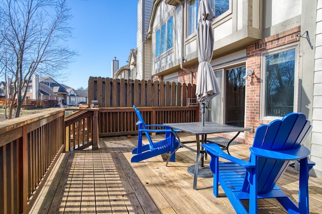 wooden terrace featuring outdoor dining area and a residential view