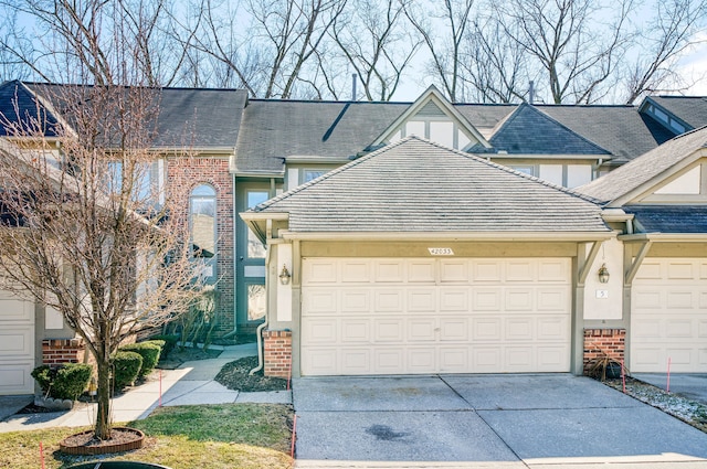 view of front facade with stucco siding, brick siding, concrete driveway, and an attached garage