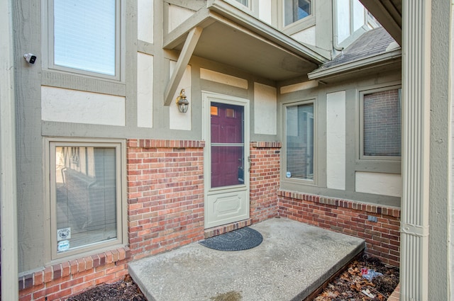 entrance to property with brick siding and roof with shingles