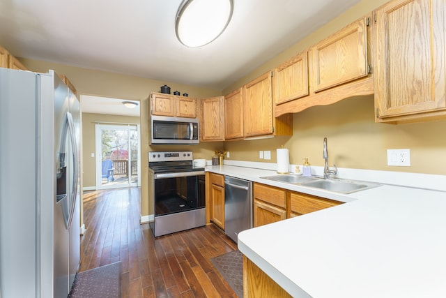 kitchen with dark wood-style flooring, light brown cabinetry, a sink, light countertops, and appliances with stainless steel finishes