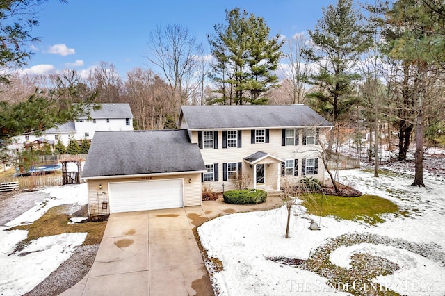 view of front of house featuring a garage, concrete driveway, and fence