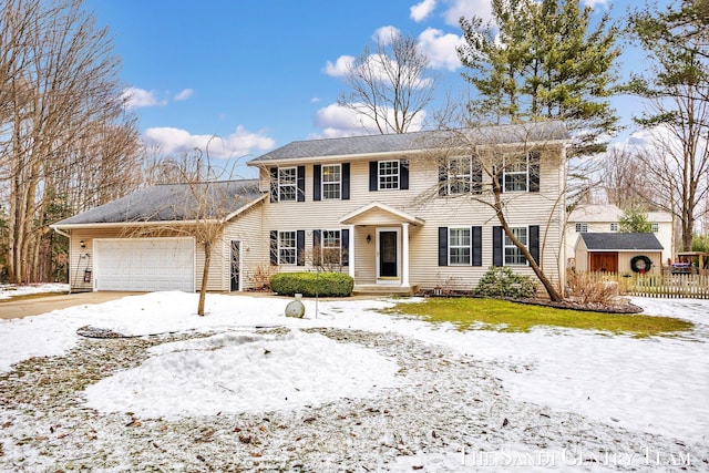 colonial home with a garage and fence