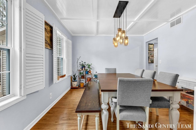 dining area with baseboards, visible vents, coffered ceiling, light wood-type flooring, and a chandelier