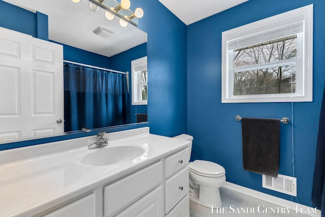 bathroom featuring baseboards, visible vents, vanity, and toilet