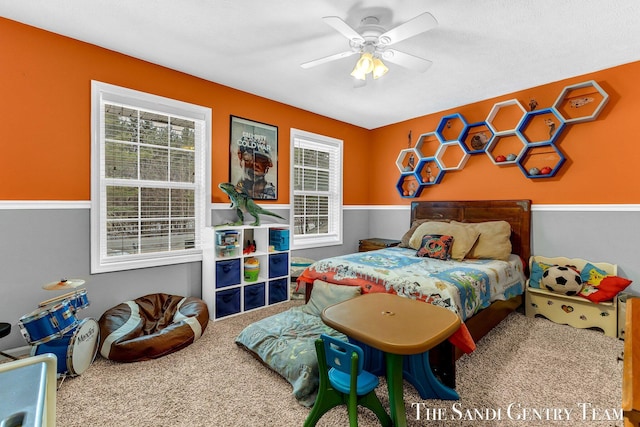 carpeted bedroom featuring multiple windows and a ceiling fan