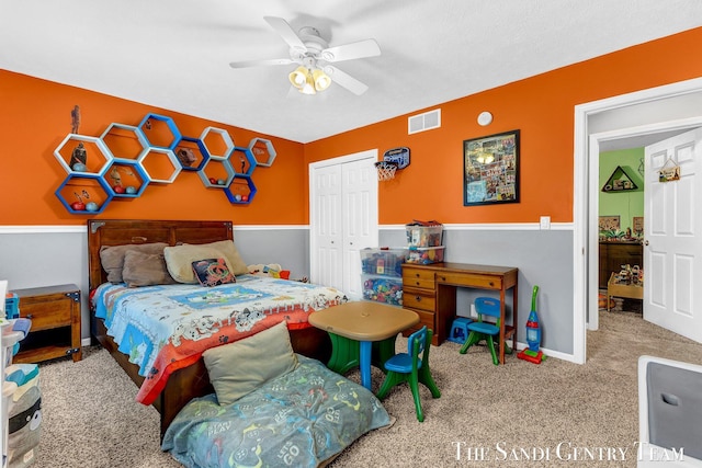 carpeted bedroom with ceiling fan, visible vents, and a closet