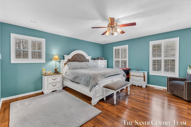 bedroom with ceiling fan, baseboards, and wood finished floors