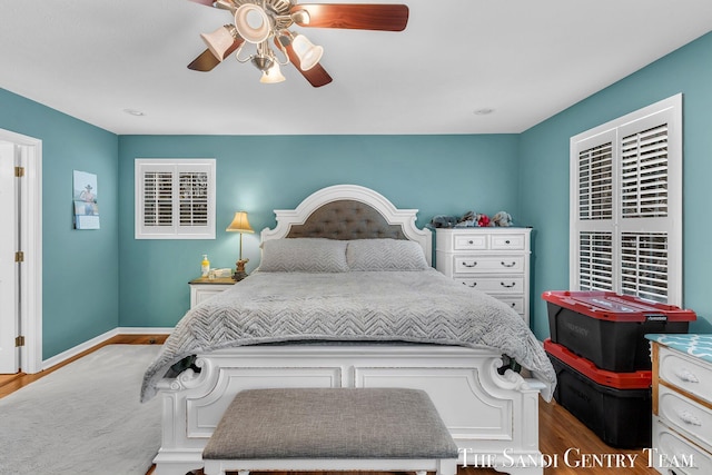 bedroom featuring ceiling fan, wood finished floors, and baseboards