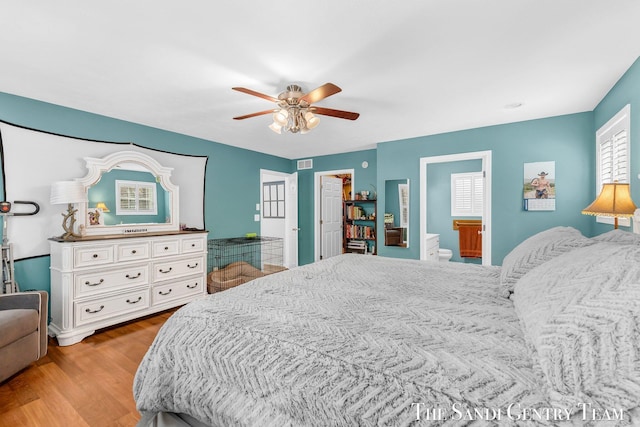 bedroom featuring connected bathroom, visible vents, ceiling fan, and wood finished floors