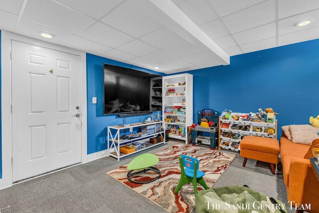 playroom with carpet floors, baseboards, and a paneled ceiling