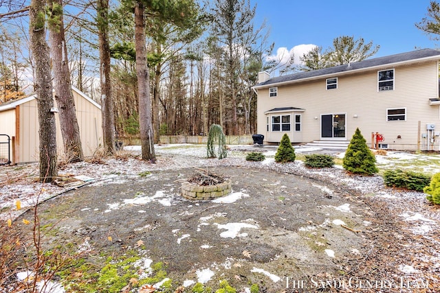 view of yard featuring entry steps and a fire pit