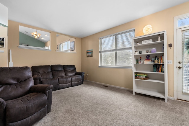 living room with an inviting chandelier, baseboards, vaulted ceiling, and carpet flooring