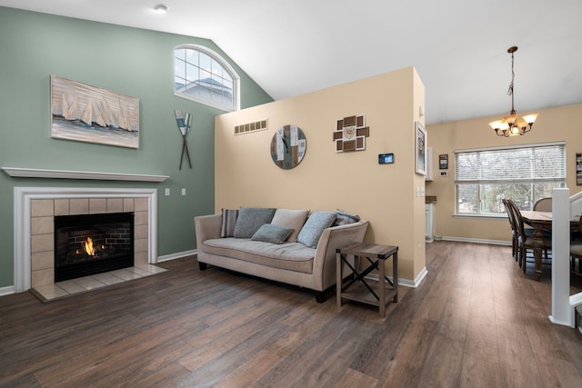 living area with wood finished floors, plenty of natural light, a tile fireplace, and visible vents