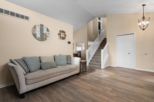 living room featuring stairway, visible vents, a notable chandelier, and wood finished floors