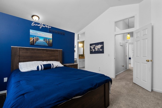 carpeted bedroom with baseboards, vaulted ceiling, and ensuite bathroom