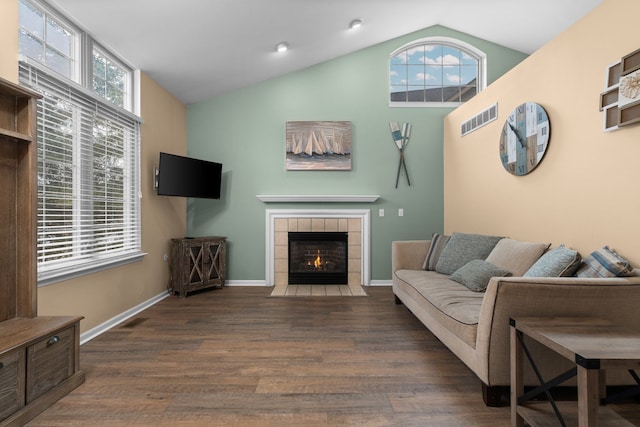 living room featuring a healthy amount of sunlight, visible vents, and wood finished floors