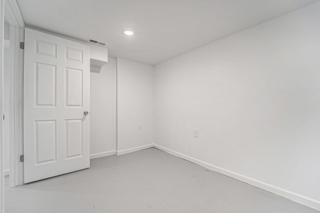 empty room featuring finished concrete floors, recessed lighting, visible vents, and baseboards