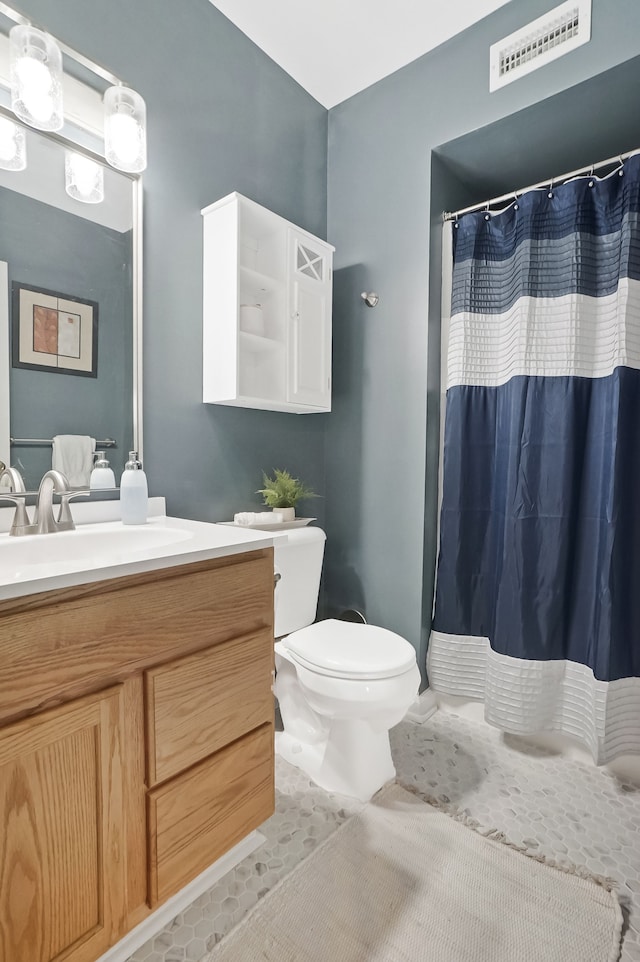 bathroom featuring visible vents, a shower with shower curtain, toilet, tile patterned floors, and vanity