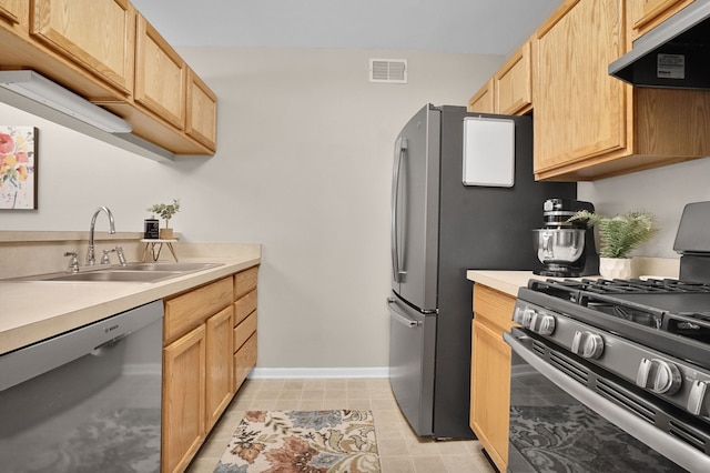 kitchen with visible vents, appliances with stainless steel finishes, light brown cabinetry, under cabinet range hood, and a sink