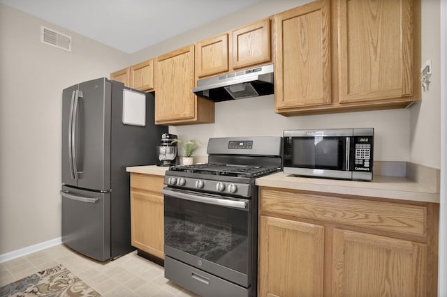 kitchen with light brown cabinets, under cabinet range hood, stainless steel appliances, visible vents, and light countertops