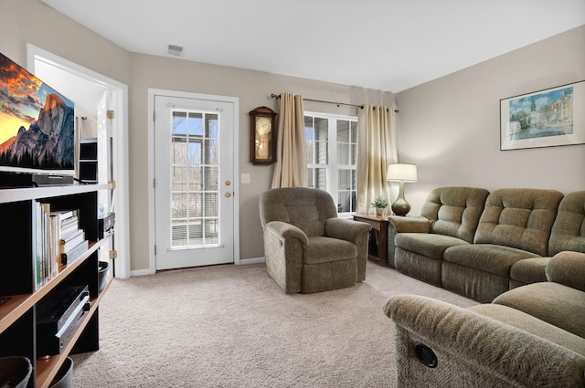 living area with carpet, visible vents, and baseboards