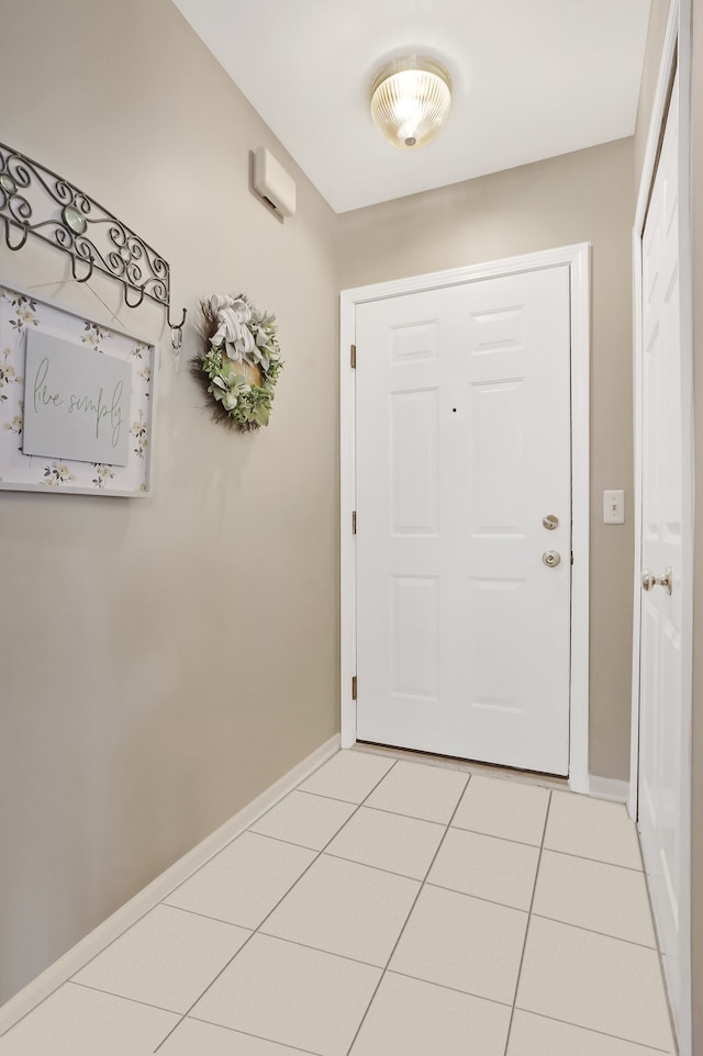 doorway to outside with light tile patterned floors and baseboards