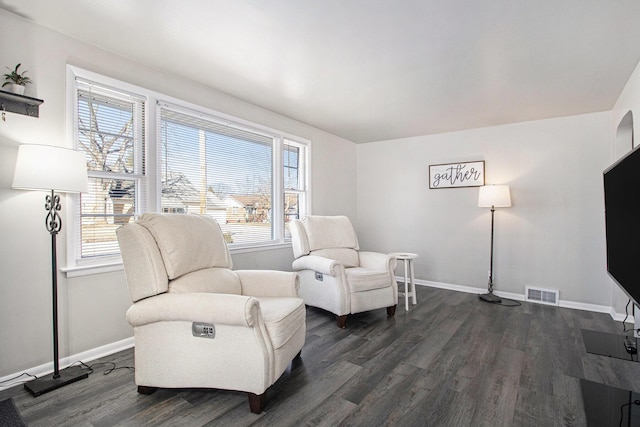 sitting room featuring dark wood-style flooring, visible vents, and baseboards