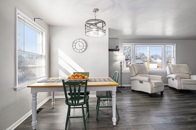 dining space with visible vents, dark wood finished floors, baseboards, and an inviting chandelier