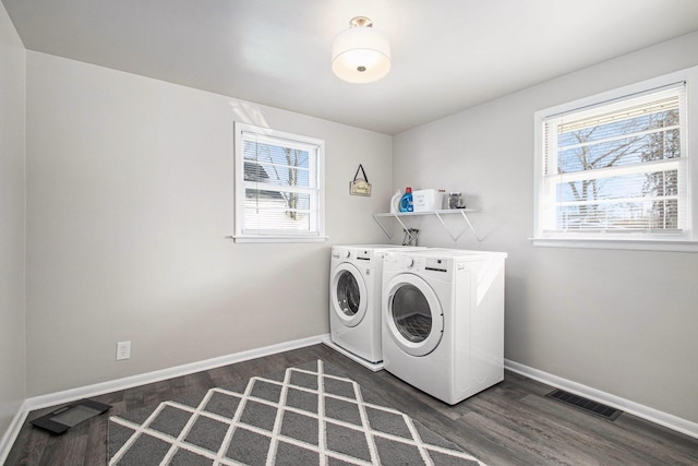 laundry room with laundry area, washer and clothes dryer, visible vents, and dark wood-style flooring