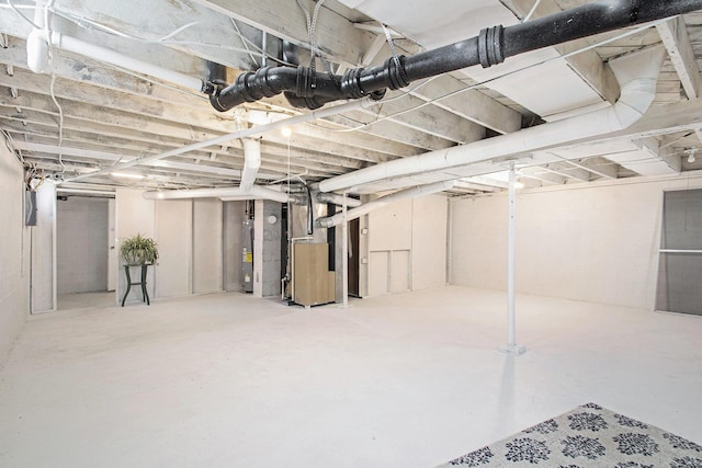 unfinished below grade area featuring water heater and heating unit