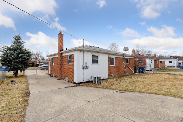 view of side of property with brick siding, crawl space, and fence