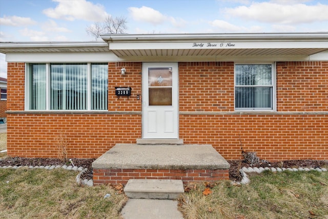 doorway to property with brick siding