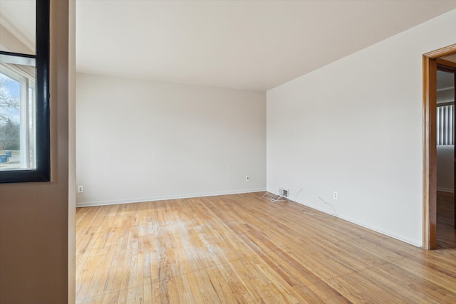 spare room featuring light wood-style floors and baseboards