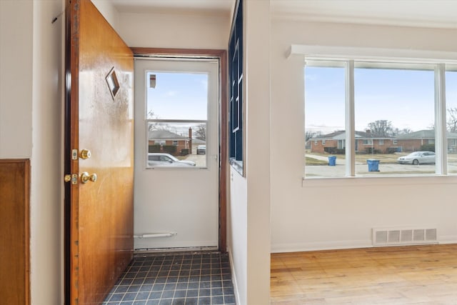 entryway featuring visible vents, baseboards, and wood finished floors