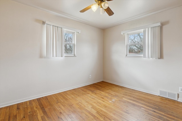 empty room with a ceiling fan, baseboards, visible vents, and light wood finished floors