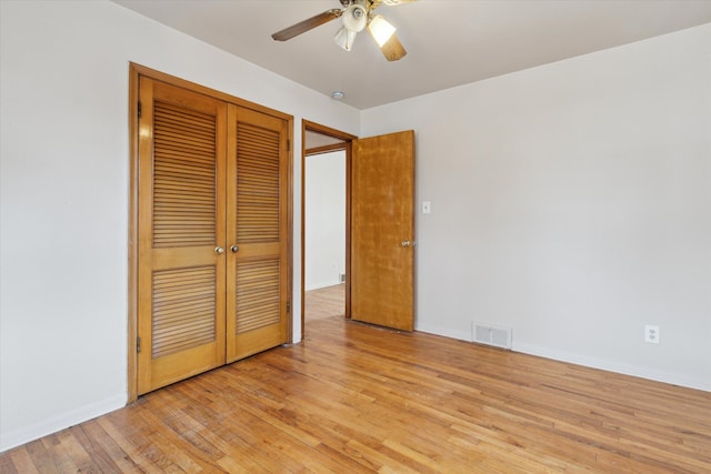 unfurnished bedroom featuring a closet, visible vents, ceiling fan, light wood-type flooring, and baseboards