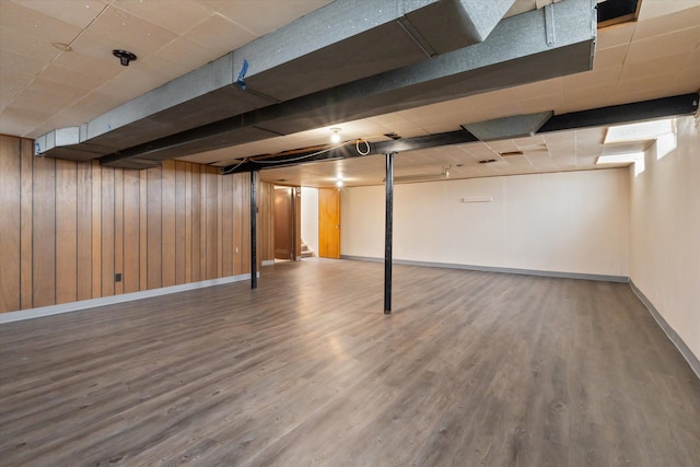 finished basement with wooden walls, wood finished floors, and baseboards