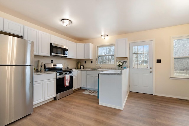 kitchen featuring a sink, light countertops, white cabinets, and stainless steel appliances