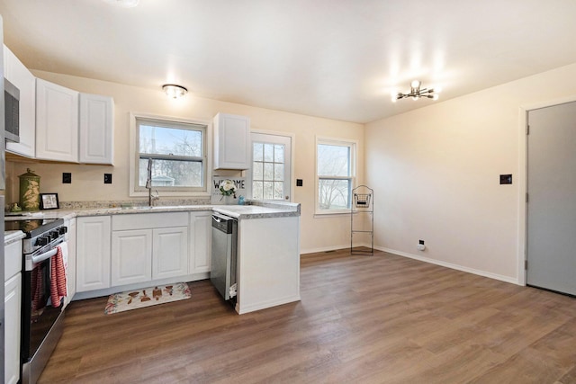 kitchen featuring white cabinetry, a healthy amount of sunlight, light wood-style floors, and stainless steel appliances