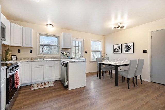 kitchen featuring plenty of natural light, light wood-style flooring, white cabinets, and stainless steel appliances