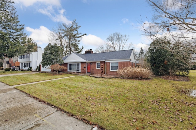 view of front facade featuring a front yard, brick siding, and a chimney