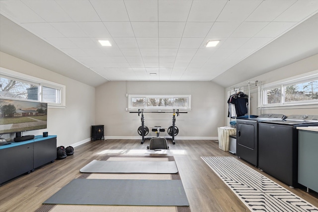 workout area featuring washing machine and clothes dryer, plenty of natural light, and vaulted ceiling