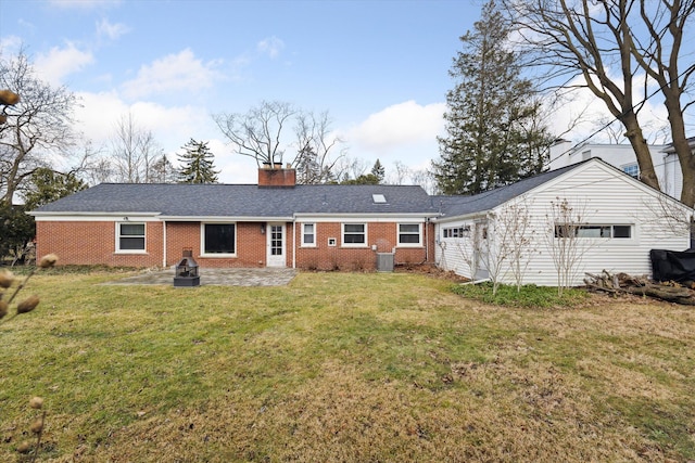 rear view of property with a patio, brick siding, a garage, and a chimney