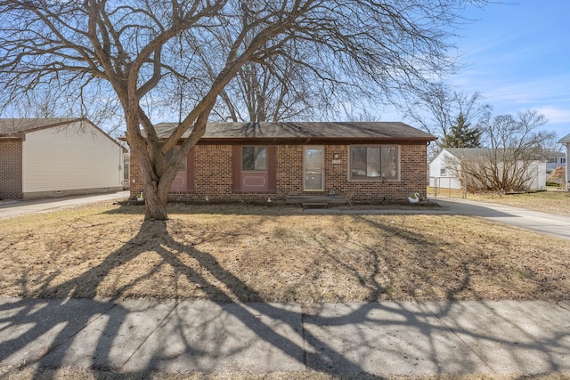 ranch-style home with brick siding and a shingled roof