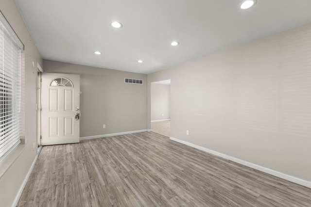 unfurnished room featuring recessed lighting, wood finished floors, visible vents, and baseboards