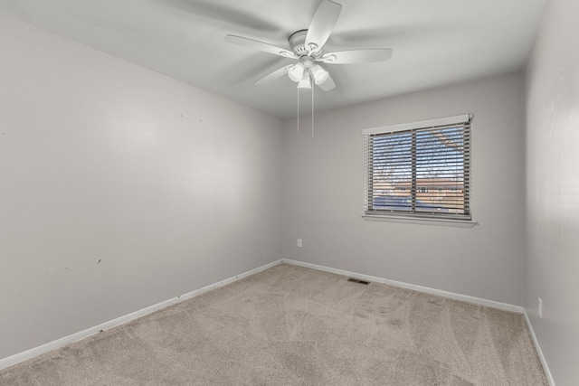 empty room with visible vents, baseboards, light colored carpet, and ceiling fan