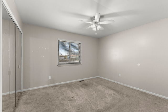 unfurnished bedroom with visible vents, a closet, baseboards, light colored carpet, and ceiling fan