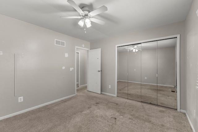 unfurnished bedroom featuring visible vents, a closet, carpet flooring, baseboards, and ceiling fan