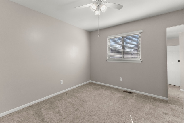 spare room with visible vents, baseboards, carpet, and ceiling fan